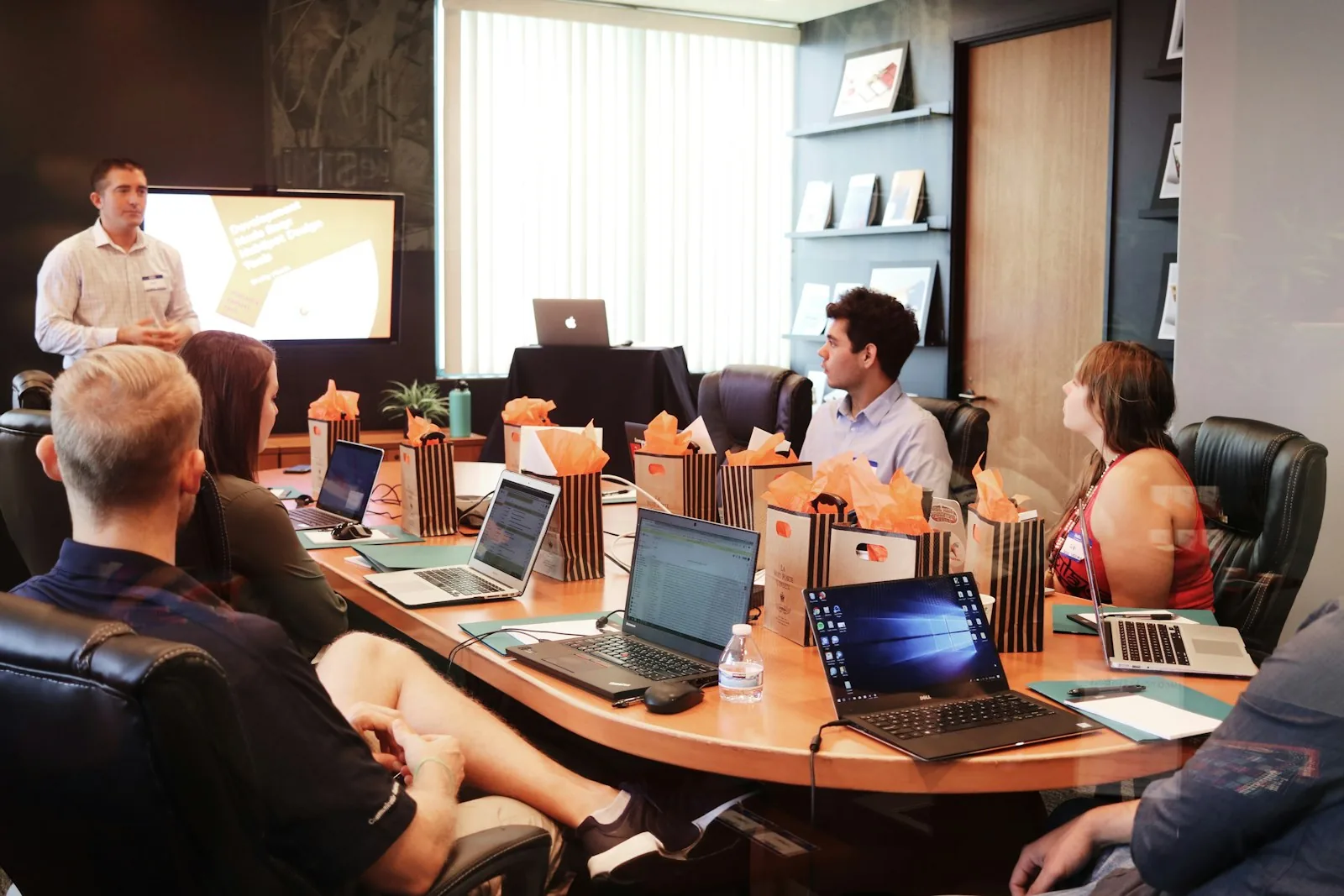 Modern office environment with professionals working on data analysis projects using multiple monitors and collaborative tools